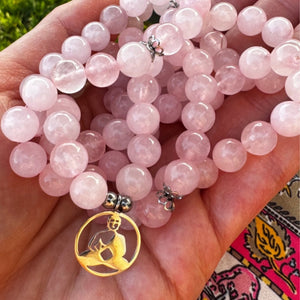 Mala transformable en bracelet multi-rangs composé de 108 perles de quartz rose naturel et d'un pendentif Bouddha méditant.
