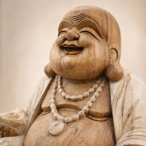 Gros plan sur le visage sculpté de Budai en bois de Suar