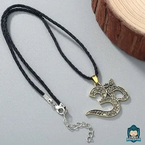 Pendentif-Signe-Om-dore-avec-chaine-en-cordon-tresse-noir-fermoir-a-mousqueton-La-Maison-de-Bouddha