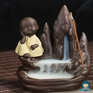 Porte-Encens-Moine-de-La-Sagesse-en-ceramique-moine-robe-jaune-hauteur-9-cm-longueur-8-cm-largeur-4-cm-poids-220-grammes-cone-backflow-La-Maison-de-Bouddha.