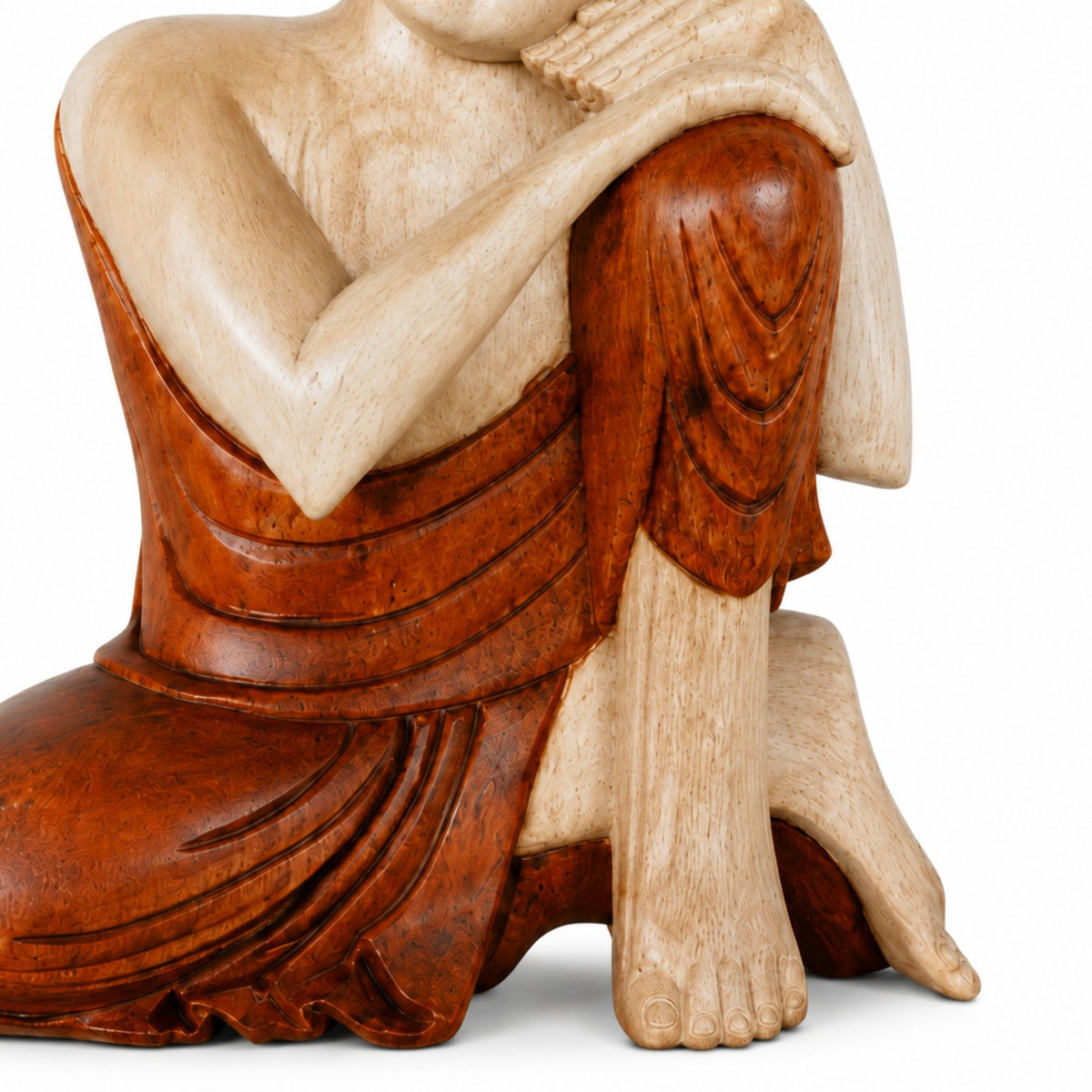 Gros plan sur les détails sculptés et le vêtement de la statue Bouddha pensif en bois de Suar
