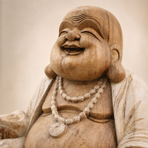 Gros plan sur le visage sculpté de Budai en bois de Suar