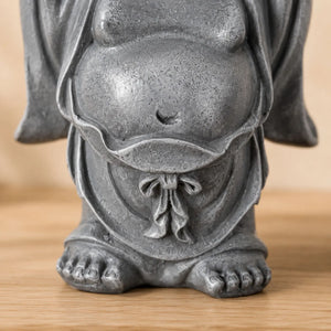 Gros plan sur le ventre, la robe et la finition de la statuette Bouddha rieur Budai en résine grise